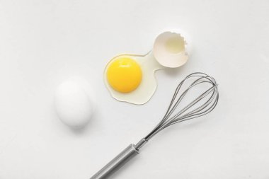 Kırılmış ve beyaz arka planda çırpılmış tavuk yumurtaları.