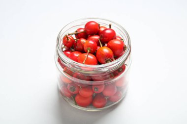 Beyaz arka planda taze gül kalçası böğürtlenli kavanoz