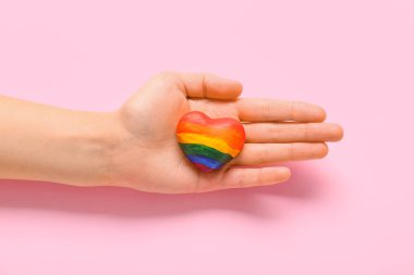 Pembe arka planda LGBT renginde kalbi olan kadın