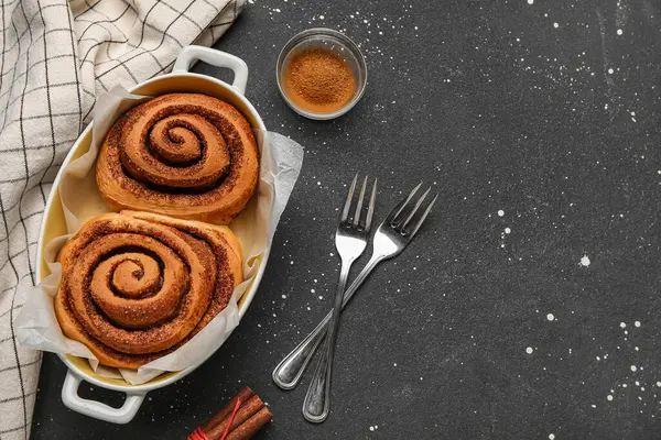 Siyah arka planda lezzetli tarçınlı fırın yemeği.