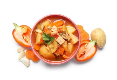 Lezzetli biftek güveci ve beyaz arka planda farklı malzemelerle dolu bir kase.