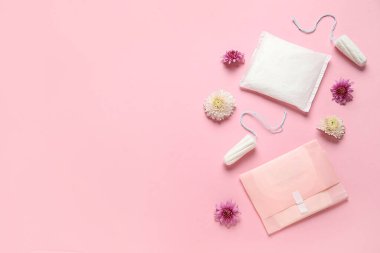 Pembe arka planda tamponlu ve çiçekli adet pedleri