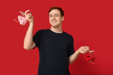 Kırmızı arka planda kelepçeli yakışıklı bir genç.