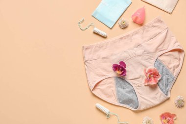 Dönem külotlu, pedli, tamponlu, regl bardaklı ve sarı arka planda güzel çiçekli kompozisyon