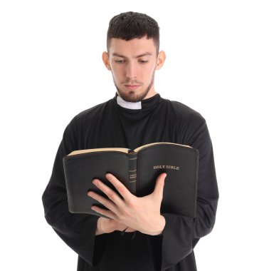 Genç rahip beyaz arka planda İncil okuyor.
