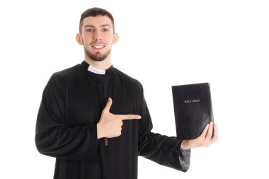 Genç rahip beyaz arka planda İncil 'i işaret ediyor.