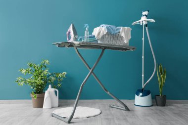 Çamaşır odasının içi ütü masası ve buharlı.