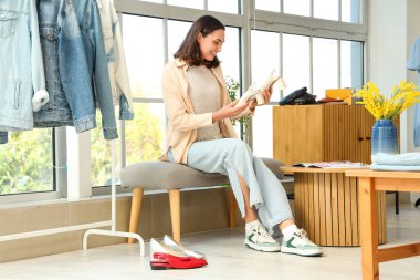 Giyim mağazasında yeni ayakkabılar seçen genç bir kadın.