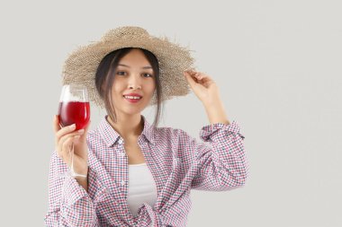 Arka planda kırmızı şarap kadehi olan genç Asyalı kadın.