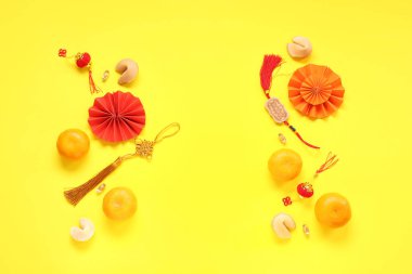 Mandalinalı şans kurabiyeleri ve sarı arka planda Çince semboller. Yeni yıl kutlaması