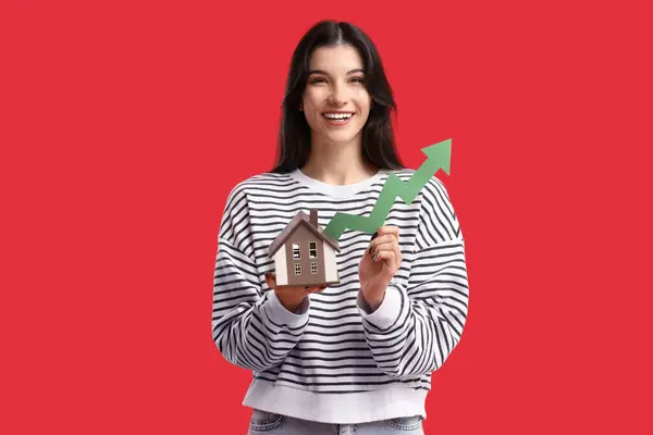 Junge Frau Mit Hausmodell Und Pfeil Auf Rotem Hintergrund Preiserhöhungskonzept — Stockfoto