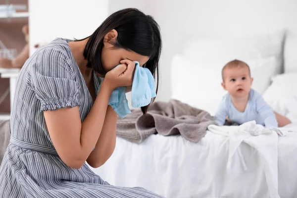 Çamaşırları yıkanmış, yatak odasında doğum sonrası depresyondan muzdarip genç bir kadın.