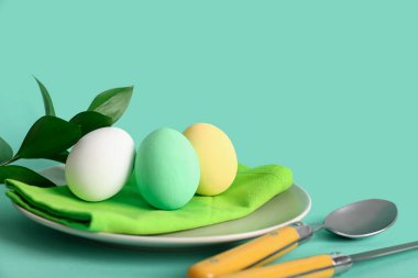 Renkli yumurtalar ve yeşil arka planda dallarla Paskalya için güzel bir sofra.