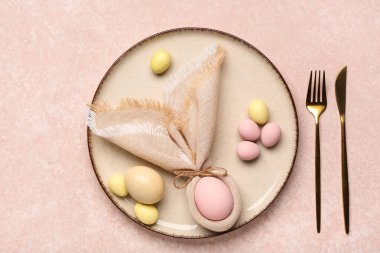 Paskalya yumurtaları, peçete ve çatal bıçak takımlarıyla süslü masa dekorları.
