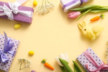 Paskalya tavşanlı hediye kutularından yapılmış çerçeve ve bej arka planda çiçekler