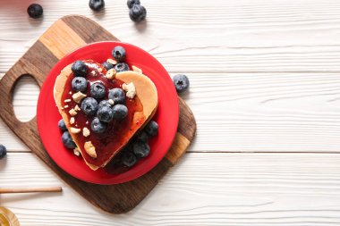 Kalp şeklinde leziz gözleme tabağı, böğürtlen ve hafif ahşap zemin üzerinde reçel. Sevgililer Günü kutlaması