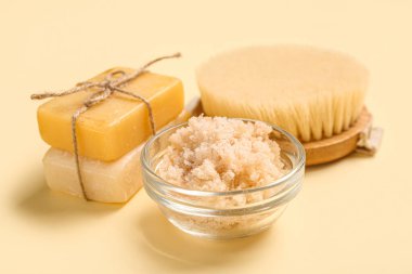 Açık sarı arka planda sabun ve fırçayla fırçala. Vücut masajı konsepti