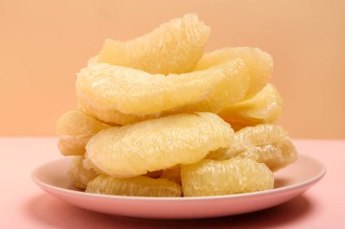 Pembe arka planda meyve parçaları olan bir tabak.