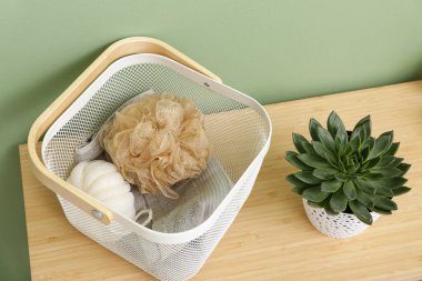 Süngerli sepet ve banyodaki ahşap masa, yakın plan.