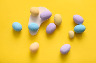 Sarı arka planda boyanmış Paskalya yumurtaları olan podyum