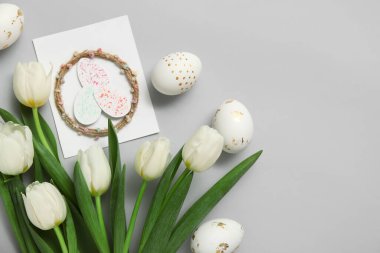Paskalya yumurtalı laleler ve beyaz arka planda neşeli kartpostallar.