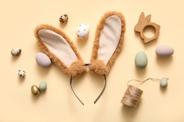Bej arka planda Paskalya yumurtası olan tavşan kulaklı.