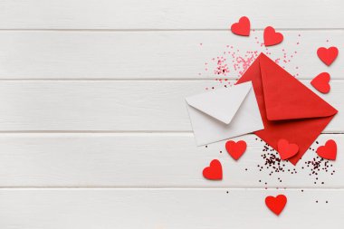 Kalpli zarflar ve beyaz ahşap arka planda konfeti. Sevgililer Günü kutlaması