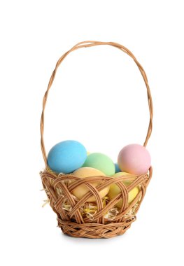 Hasır sepet beyaz zemin üzerine boyalı Paskalya yumurtaları ile