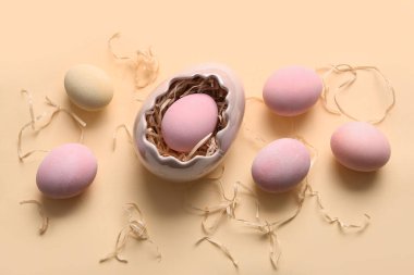 Paskalya yumurtası ve bej arka planda kağıt şeritli tutucu