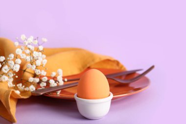 Paskalya için güzel bir sofra, yumurta ve leylak arka planda çiçekler.