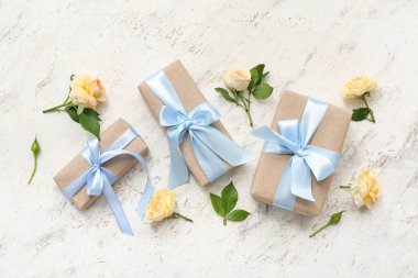 Güzellik paketlenmiş hediye kutuları ve arka planda çiçek dekoru.