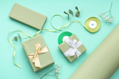 Paket kağıtlı hediye kutuları ve turkuaz arka planda çingene çiçekleri. Uluslararası Kadınlar Günü