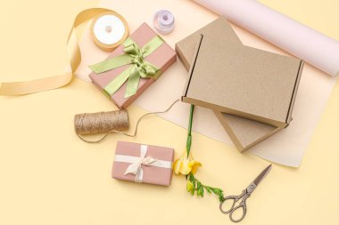 Paket kağıtlı hediye kutuları ve sarı arka planda güzel bir çiçek. Uluslararası Kadınlar Günü