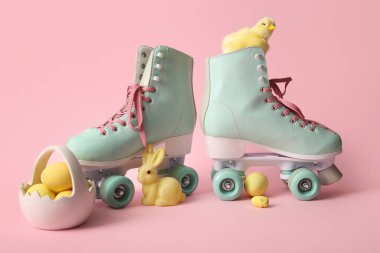 Paskalya yumurtalı klasik patenler, pembe arka planda oyuncak tavşan ve piliç.