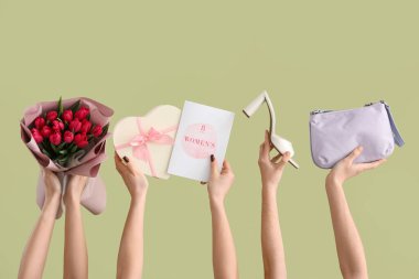 Bir buket lale, hediye kutusu ve yeşil arka planda neşeli kartpostallı kadın elleri. Uluslararası Kadınlar Günü için Alışveriş