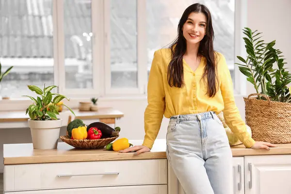 Evde taze sebzeli güzel bir kadın var.