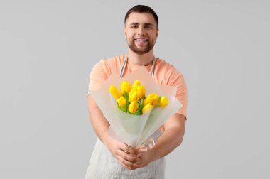 Hafif arka planda çiçekleri olan erkek çiçekçi.