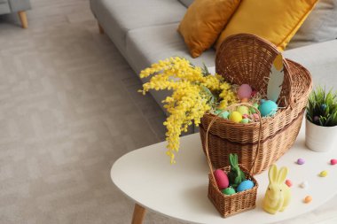 Mimoza çiçekli sepetler, Paskalya yumurtası ve oyuncak tavşan oturma odasında.