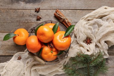 Bir sepet tarçınlı tatlı mandalina ve ahşap arka planda yıldız anason.