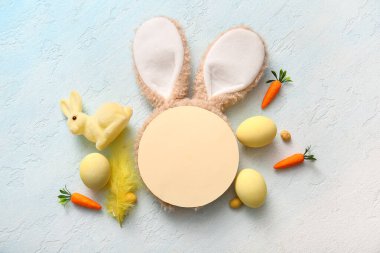 Paskalya yumurtası, havuç ve açık mavi grunge arka planında boş tebrik kartı olan tavşan kulaklı.