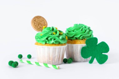 Beyaz arka planda Aziz Patrick Günü için dekorasyonu olan lezzetli kekler.
