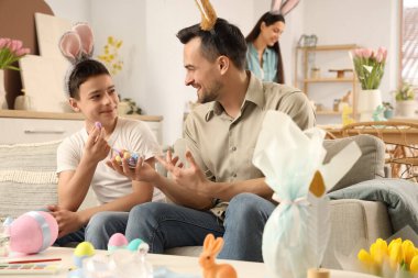 Paskalya yumurtaları ve evde babası olan küçük çocuk.