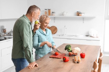 Mutfakta domates kesen olgun bir çift.