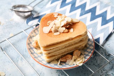 Kalp şeklinde leziz gözlemeler ve mavi arka planda fındıklar, yakın plan. Sevgililer Günü kutlaması