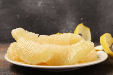 Gri grunge masasında meyve parçalarıyla dolu bir tabak.