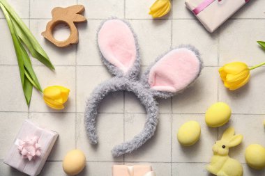 Paskalya yumurtalı tavşan kulakları, lale çiçekleri ve beyaz fayanslı hediye kutuları.