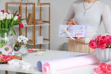 Güzel hediye kutusu olan bir kadın, paketleme malzemeleri ve lale çiçekleri. Uluslararası Kadınlar Günü