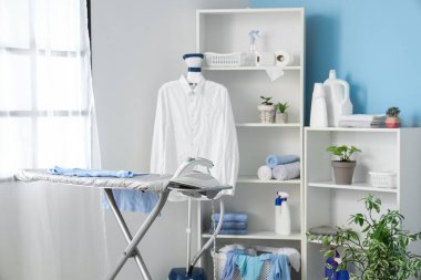 Ütü masası ve buharlı modern çamaşır odasının içi.