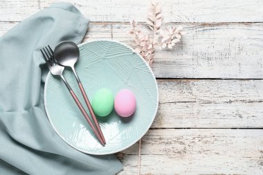 Paskalya için çok güzel bir sofra. Yumurtalar ve hafif ahşap arka planda dallar.