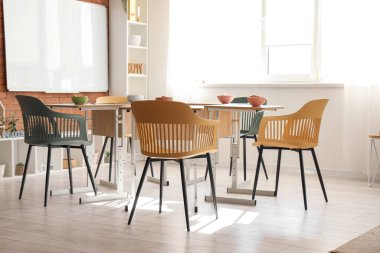 Masaların üzerinde kahvaltı olan anaokulu.